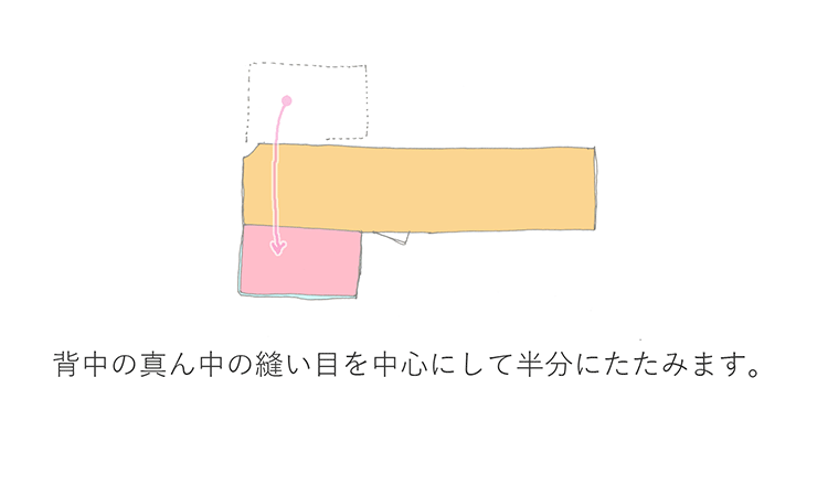 背中の真ん中の縫い目を中心にして半分にたたみます。